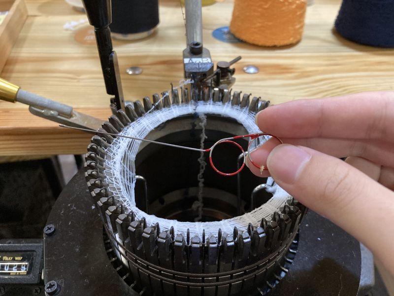 Industrial computerized knitting machine producing knit fabric