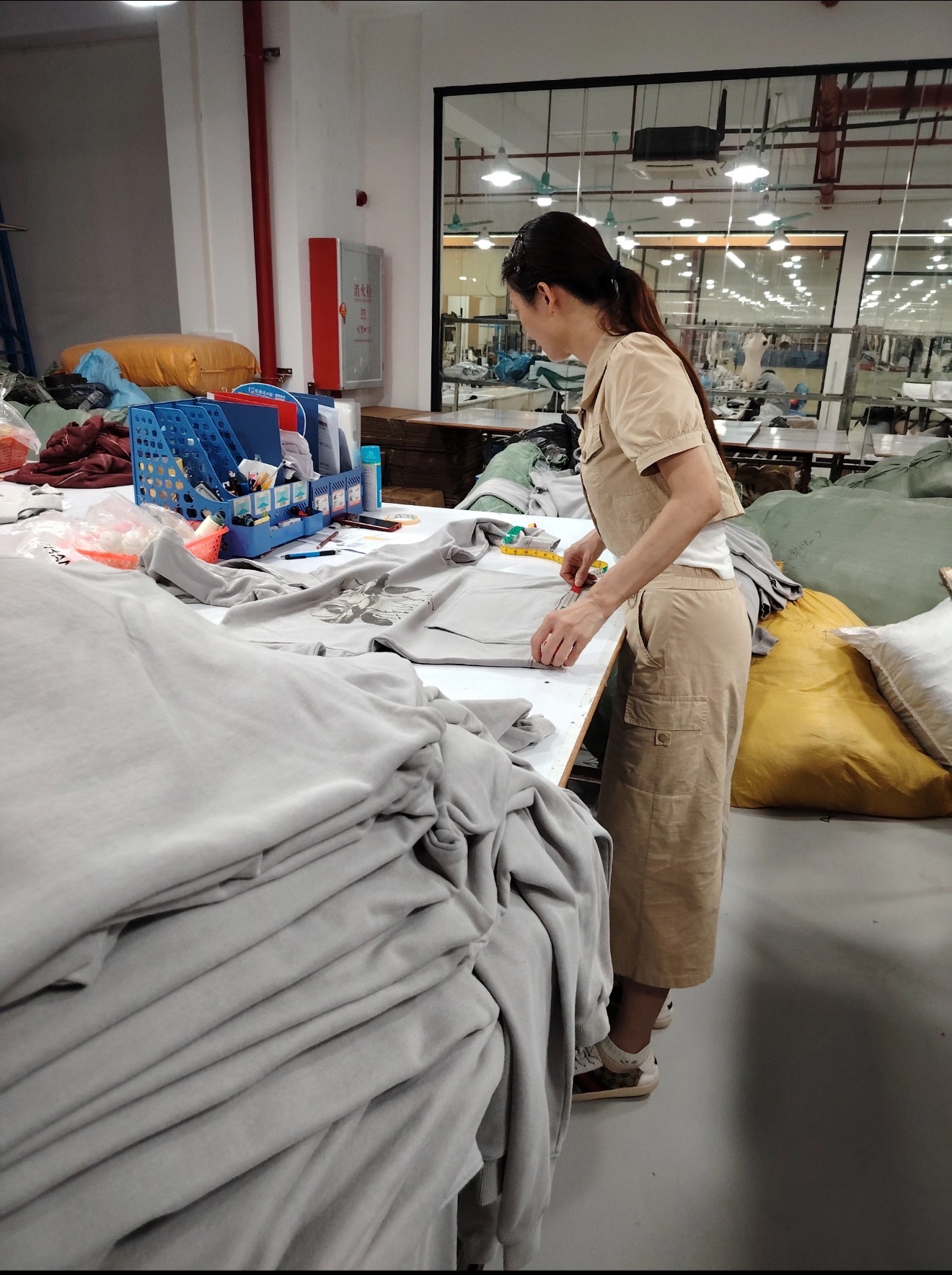 Pre-Shipment Inspection — final AQL check measuring and verifying finished knitwear before container loading